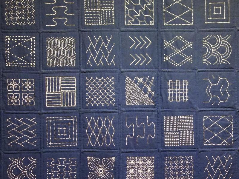 Patchwork tæppe med mønstre holdt i blå farver